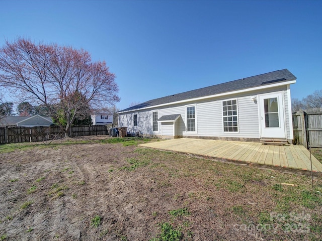 rear view of house featuring a fenced backyard and a deck