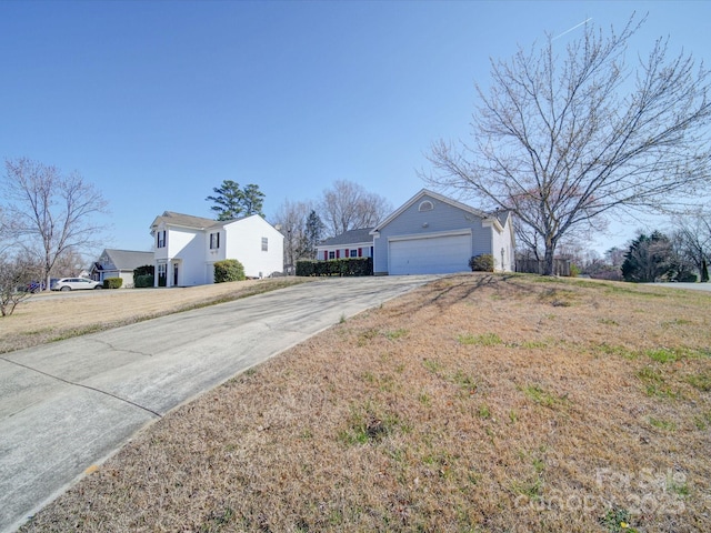 view of front of property featuring a garage, concrete driveway, and a front lawn