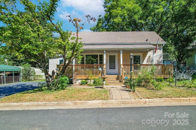 bungalow-style house with aphalt driveway, a porch, and roof with shingles