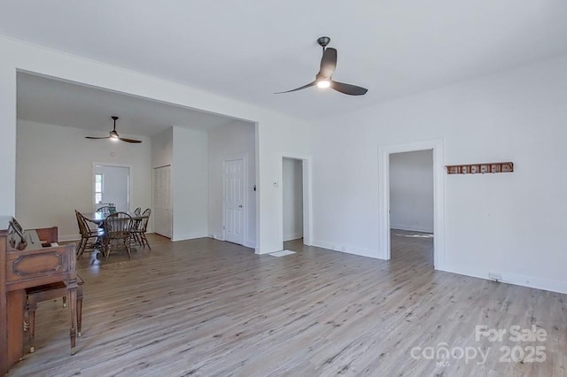 interior space with ceiling fan, baseboards, and wood finished floors