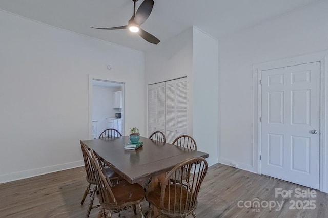 dining space with ceiling fan, baseboards, and wood finished floors