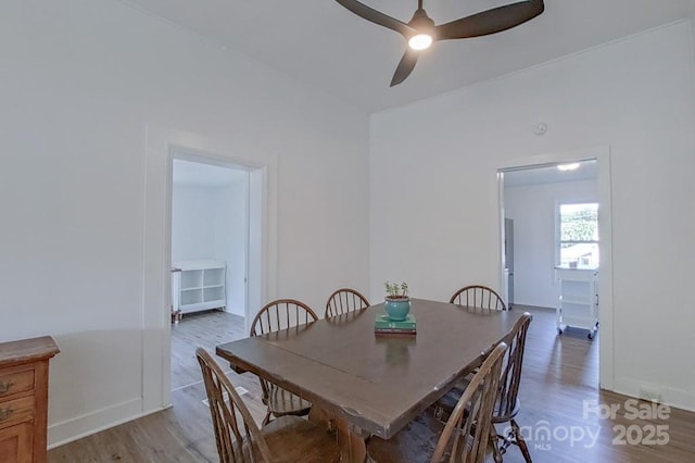 dining space with light wood-type flooring, a ceiling fan, and baseboards