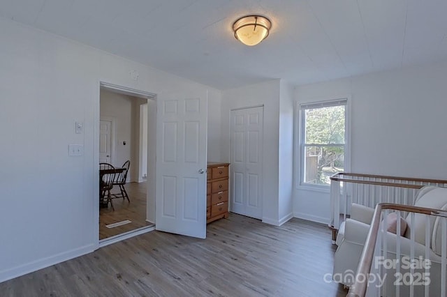 unfurnished bedroom featuring a closet, baseboards, and wood finished floors