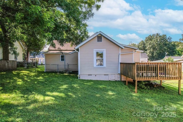 back of property with crawl space, fence, a lawn, and a wooden deck