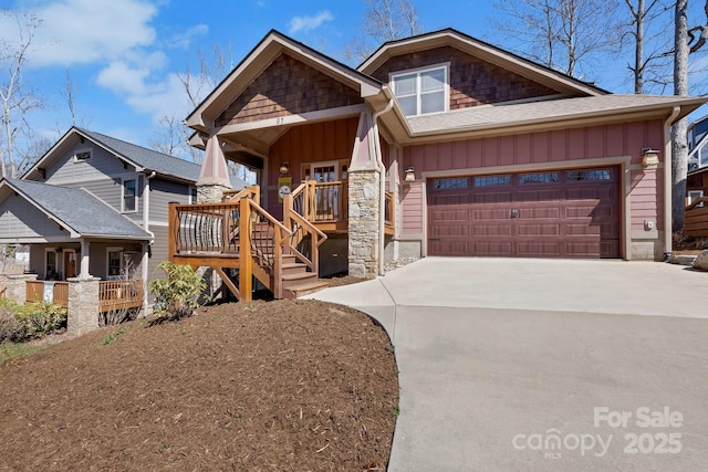 craftsman house with driveway, stone siding, a porch, board and batten siding, and a garage