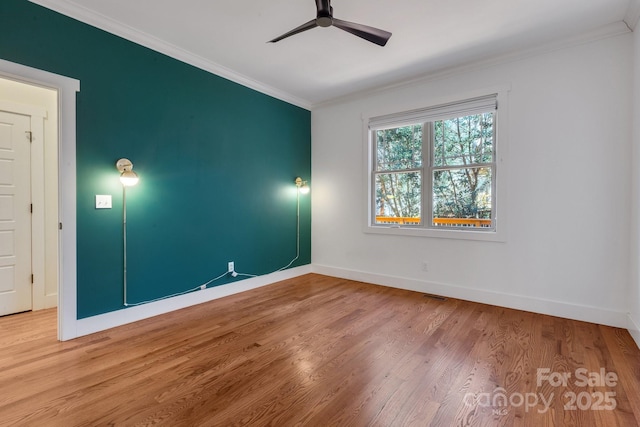 unfurnished room with wood finished floors, visible vents, baseboards, ceiling fan, and crown molding