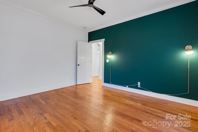 unfurnished room with baseboards, crown molding, ceiling fan, and wood finished floors