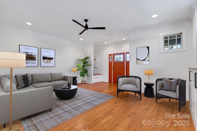 living area with light wood finished floors, recessed lighting, crown molding, and ceiling fan