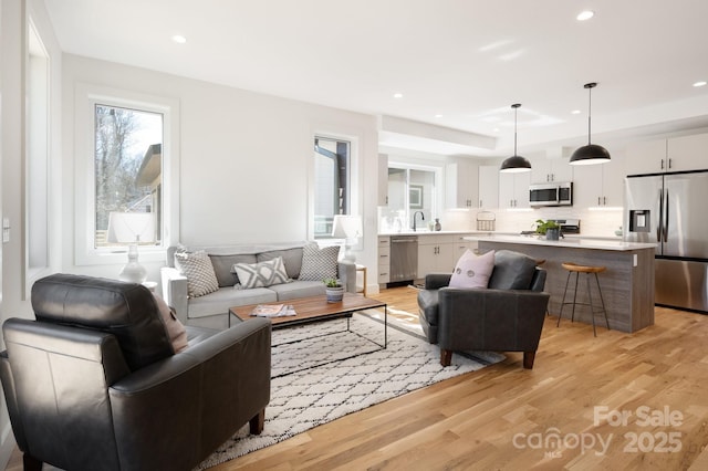 living room with light wood-style flooring and recessed lighting