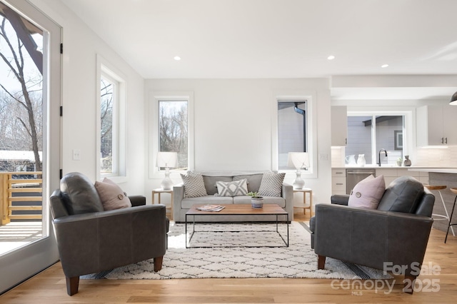 living room with light wood-style flooring and recessed lighting