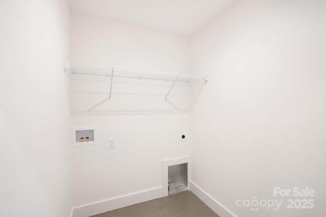 laundry area featuring washer hookup, electric dryer hookup, tile patterned flooring, laundry area, and baseboards