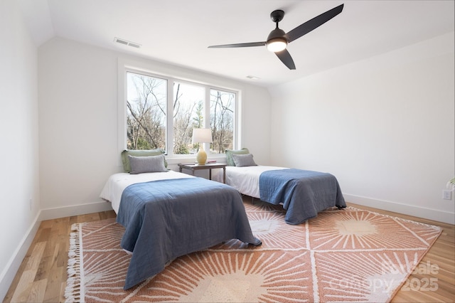 bedroom featuring a ceiling fan, visible vents, baseboards, and wood finished floors