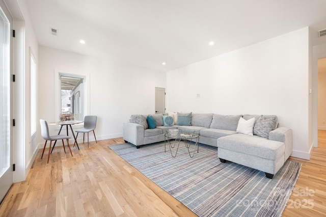 living area with baseboards, light wood finished floors, visible vents, and recessed lighting