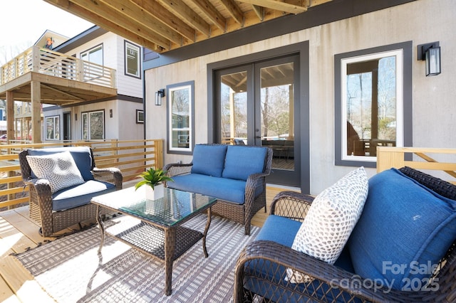 exterior space with french doors, a balcony, and an outdoor living space