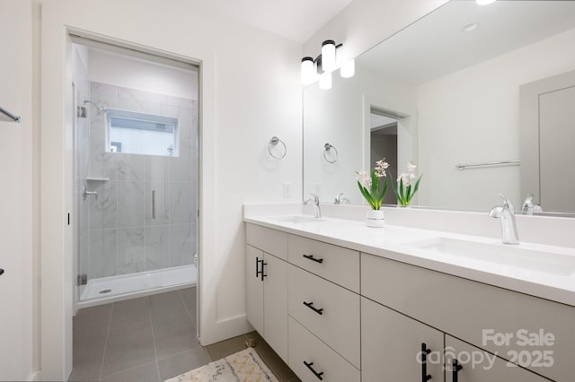 full bath featuring a stall shower, tile patterned flooring, a sink, and double vanity