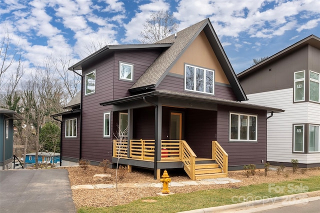 view of front of home with a porch and roof with shingles