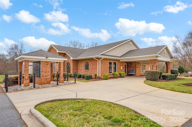 single story home with brick siding, driveway, a shingled roof, and a front yard