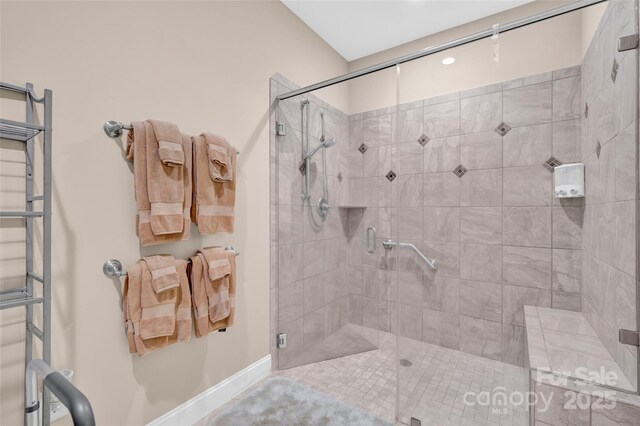 bathroom with a shower stall and baseboards