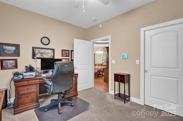 office area featuring ceiling fan with notable chandelier, carpet, and baseboards