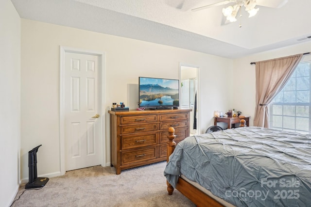 bedroom featuring visible vents, baseboards, ceiling fan, a textured ceiling, and light carpet