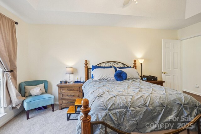 bedroom featuring baseboards and light carpet