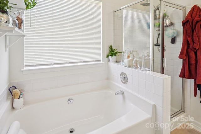 full bathroom featuring a shower stall and a garden tub