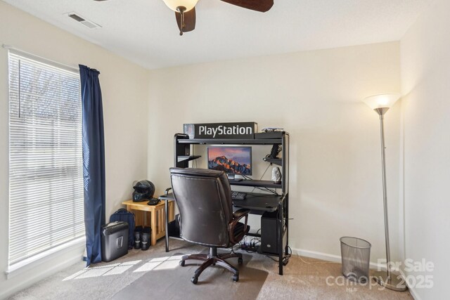 carpeted office space with visible vents, ceiling fan, and baseboards