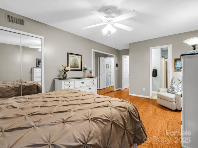 bedroom featuring visible vents, connected bathroom, baseboards, light wood-style floors, and a ceiling fan