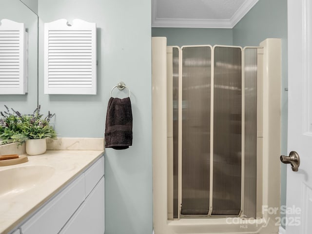 bathroom with vanity, a stall shower, and ornamental molding