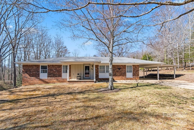 ranch-style house with a porch, brick siding, concrete driveway, a carport, and a front lawn