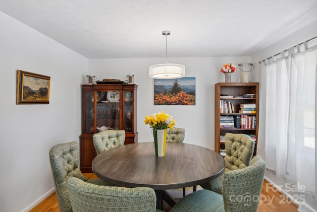 dining room with light wood-style floors and baseboards