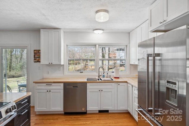 kitchen featuring a wealth of natural light, appliances with stainless steel finishes, light wood-style floors, and a sink