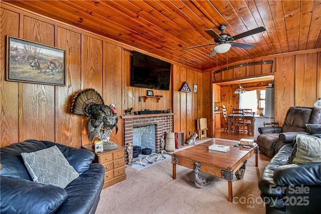 living room with wooden walls, a brick fireplace, carpet, wooden ceiling, and a ceiling fan
