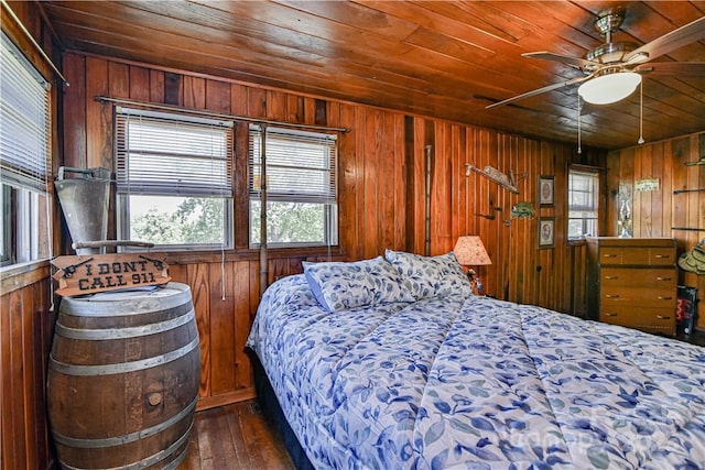 bedroom with dark wood-type flooring, wooden walls, and wood ceiling
