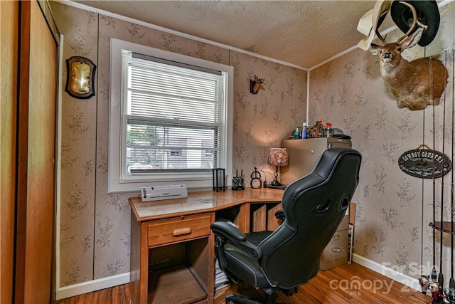 office area with baseboards, a textured ceiling, wood finished floors, and wallpapered walls