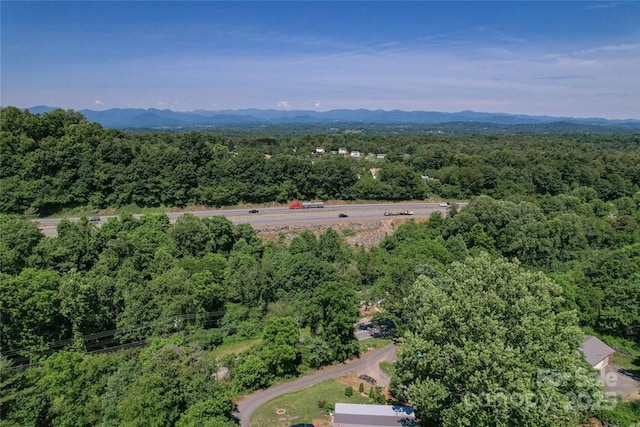drone / aerial view featuring a mountain view and a view of trees