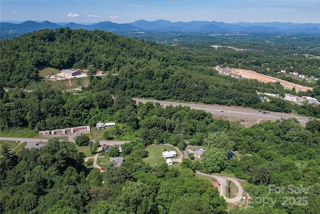 drone / aerial view featuring a mountain view and a view of trees