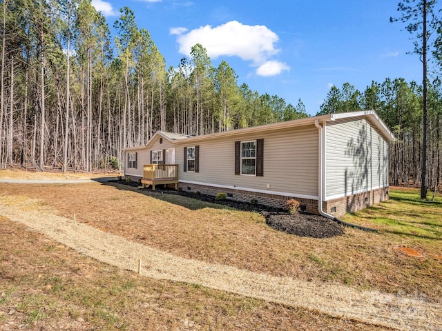 manufactured / mobile home with crawl space, a front yard, and a wooden deck