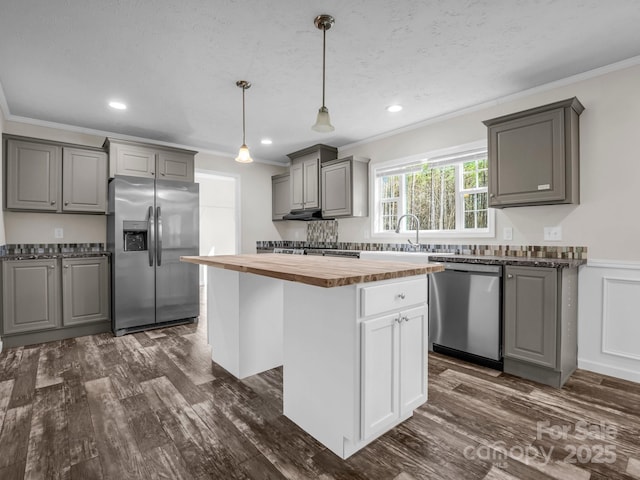 kitchen featuring dark wood-style floors, wood counters, appliances with stainless steel finishes, gray cabinets, and crown molding