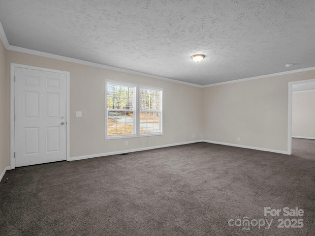 spare room featuring dark colored carpet, crown molding, and baseboards