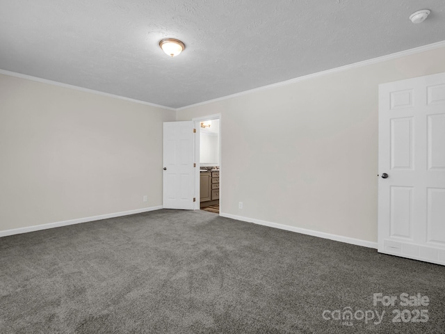 unfurnished room featuring a textured ceiling, dark colored carpet, ornamental molding, and baseboards