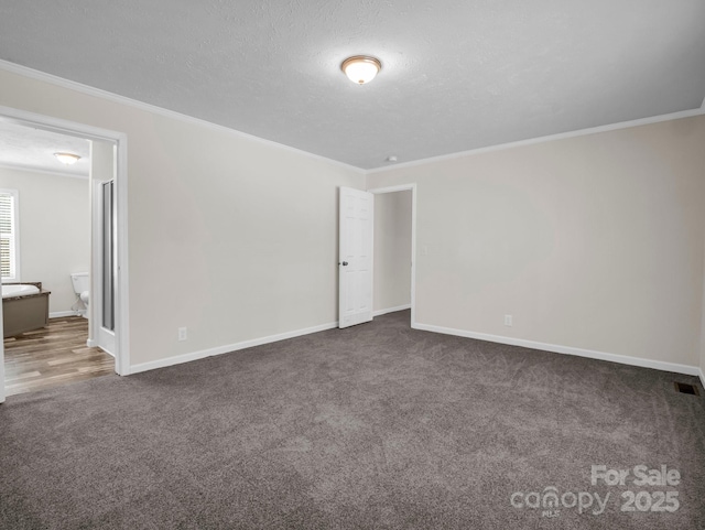 carpeted empty room featuring baseboards, visible vents, ornamental molding, and a textured ceiling