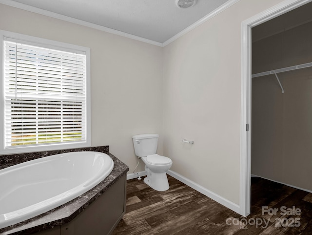 full bathroom featuring baseboards, toilet, ornamental molding, wood finished floors, and a garden tub