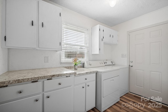 laundry room with washer and dryer, cabinet space, a textured ceiling, and dark wood finished floors