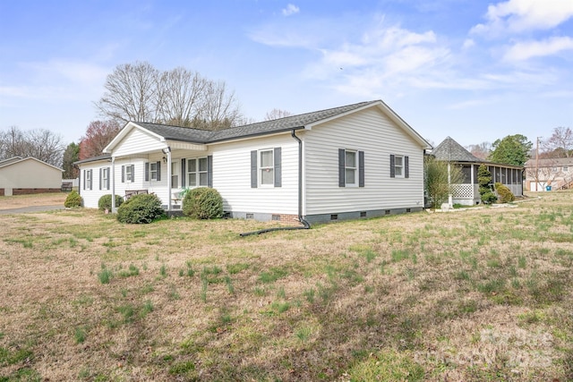 exterior space featuring crawl space, a front lawn, and a sunroom