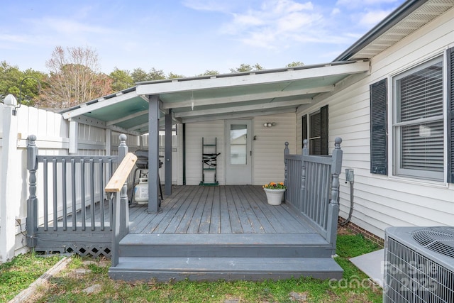 wooden terrace featuring central AC unit and fence