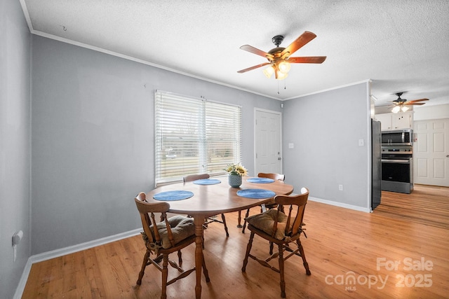 dining space with light wood-type flooring, baseboards, and ornamental molding