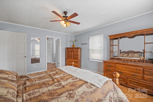 bedroom featuring a textured ceiling, baseboards, and ornamental molding