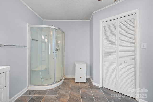 full bathroom featuring baseboards, ornamental molding, a stall shower, a textured ceiling, and vanity