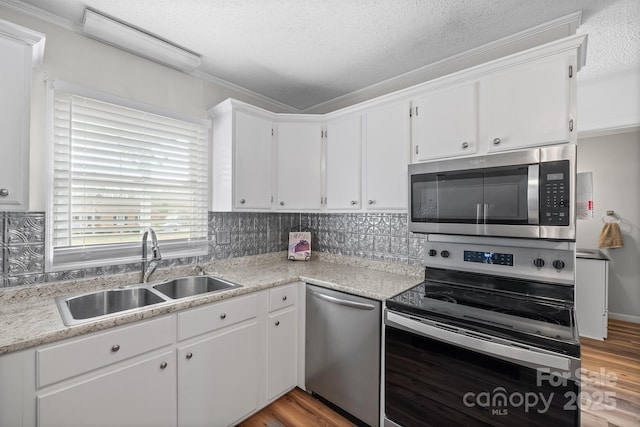 kitchen with a sink, white cabinetry, light wood finished floors, and stainless steel appliances